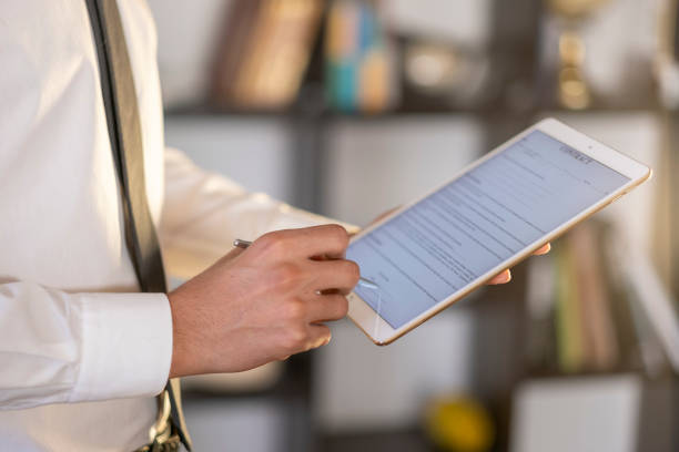 istock Businessman signing digital contract on tablet with stylus 2194664811