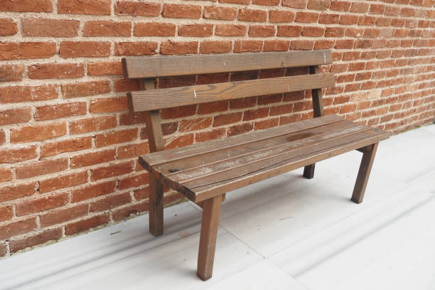 istock A Rustic Wooden Bench Placed Against a Sturdy Brick Wall for Enhancing Outdoor Spaces 2194665418