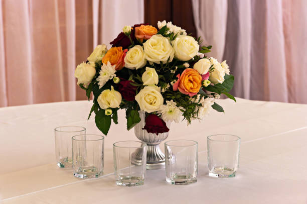 istock A vase filled with white and orange flowers sitting on a table 2194668377