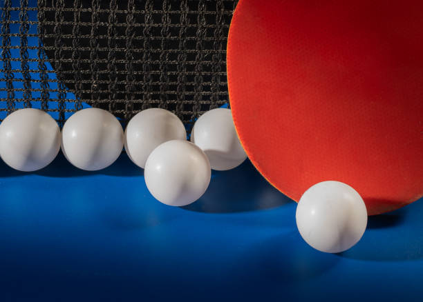 istock Ping pong rackets and balls on a blue table with net. 2194671131