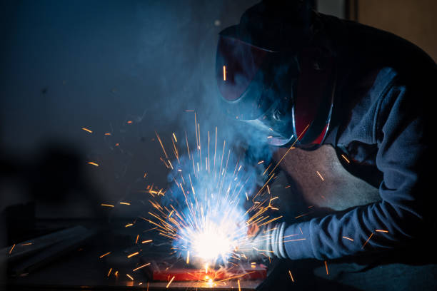 istock Industrial worker welding metal and producing sparks in workshop 2194671745