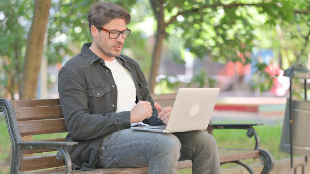 istock Middle Aged Man Doing Video Chat Outdoor on Laptop 2194673327