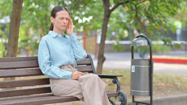 istock Tired Woman having Headache while Sitting on Bench 2194674546