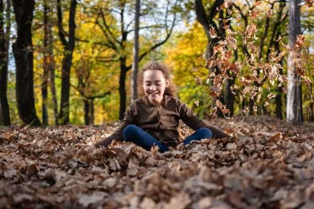 Beautiful young woman laughing and enjoying a sunny day of autumn in an alley.