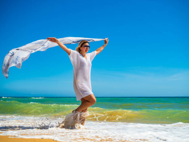 istock Beautiful mature woman walking on beach 2194677793