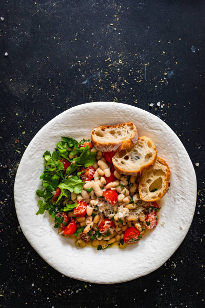 istock White beans with cherry tomatoes, parmesan, lemon and garlic in frying pan on black table 2194677828