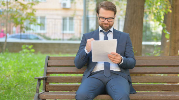 istock Businessman in Glasses Celebrating while Reading Documents Outdoor 2194678338