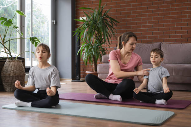 istock family doing yoga at home 2194679136