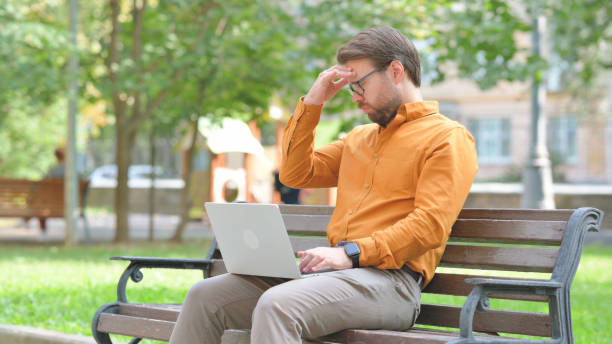 istock Young Man with Migraine Using Laptop Outdoor 2194679338