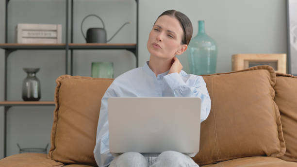 istock Woman with Neck Pain Using Laptop at Home 2194679749