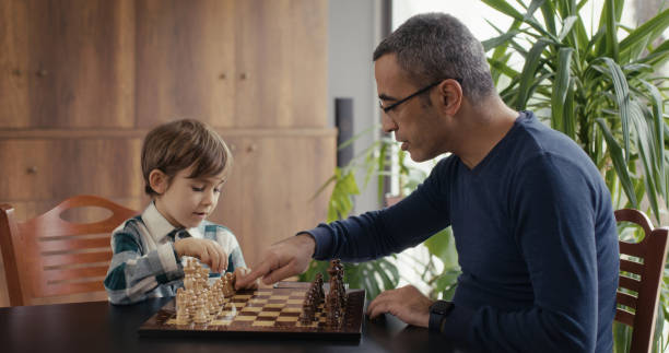 istock Father And Little Son Playing Chess Together At Home 2194680721