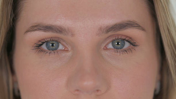 istock Close up of Female Blinking Eyes on White Background 2194681549