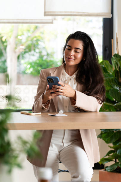 istock Businesswoman using smartphone at brunch in modern cafe 2194682344