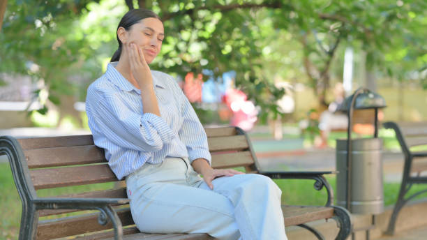 istock Mixed Race Woman with Toothache Sitting Outdoor 2194684085