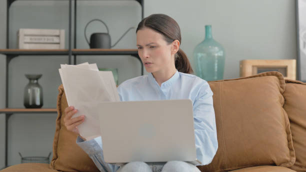 istock Woman Cheering Successful Paperwork at Home 2194684840