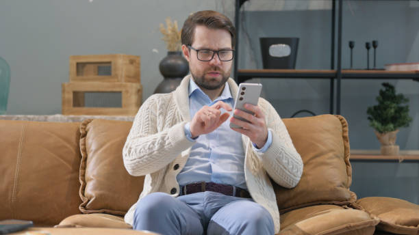 istock Middle Aged Man Browsing Internet on Phone at Home 2194685542