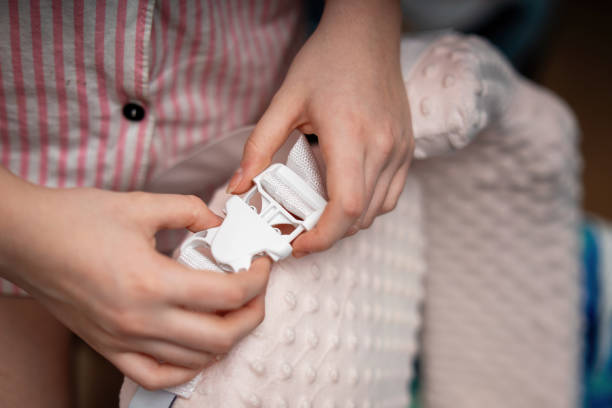 istock women's hands fastening a plastic buckle on a soft foam breastfeeding pillow, designed for comfortable feeding of infants 2194689519