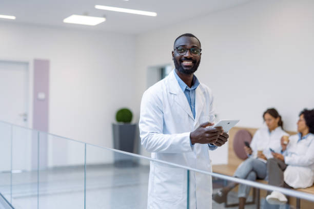 istock Smiling doctor using tablet in hospital corridor 2194689928