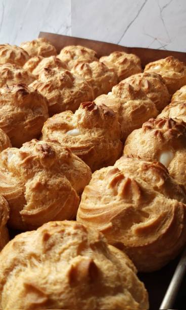 istock Light and airy choux pastry with a golden crust, filled with rich cream or custard. This elegant and versatile dessert offers a perfect balance of texture and sweetness. 2194689958