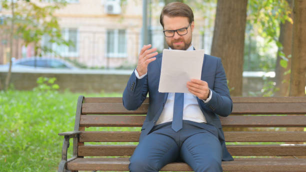 istock Businessman in Glasses Shocked while Reading Documents Outdoor 2194690763