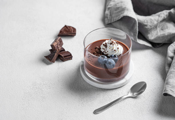 istock Chocolate pudding in a glass with whipped cream and fresh blueberry on a light background 2194690786