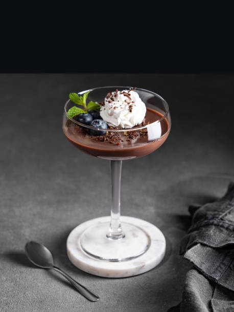 istock Chocolate pudding in a glass with whipped cream, fresh blueberries and mint on a dark background 2194690789