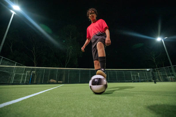 istock Young soccer player dribbling ball during night training session 2194693968
