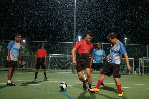 istock Soccer players playing game during rainy night 2194693992