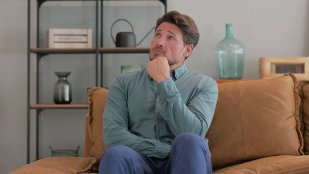 istock Thinking Middle Aged Man Sitting on Sofa at Home 2194694558