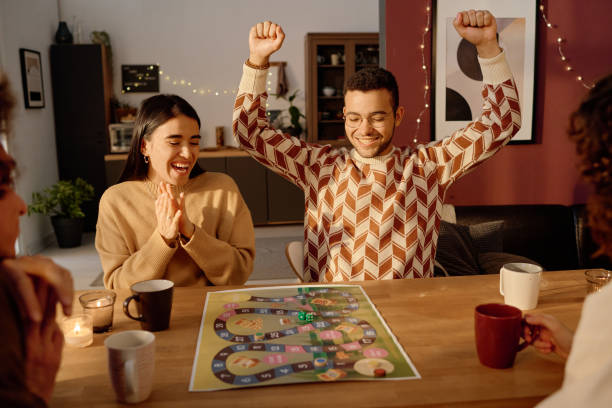 istock Friends Looking at Dice on Playing Field 2194702338