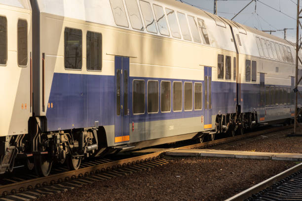 istock A sleek, double-decker electric train pulls into a busy railway station platform as sunlight bathes the scene in warm tones 2194702911