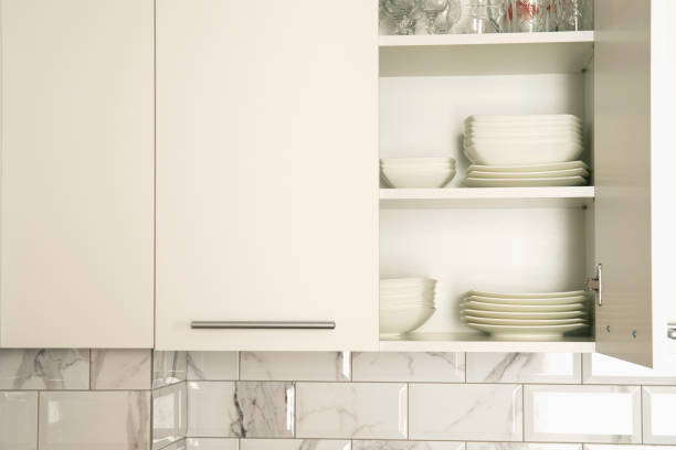 Clean white painted wooden kitchen cabinet with chrome handles showing subtle wear and aging