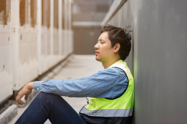istock Asian male worker tired and thirst of water at construction site. Construction builder worker sitting and feel sick, have a headache. Health safe of work and safety first concept 2194704303