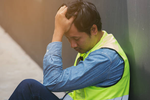 istock Asian male worker tired and thirst of water at construction site. Construction builder worker sitting and feel sick, have a headache. Health safe of work and safety first concept 2194704337