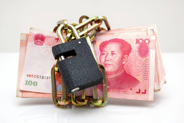 Paper currency with a lock and chain around it (Chinese yuan note) isolated on white background.