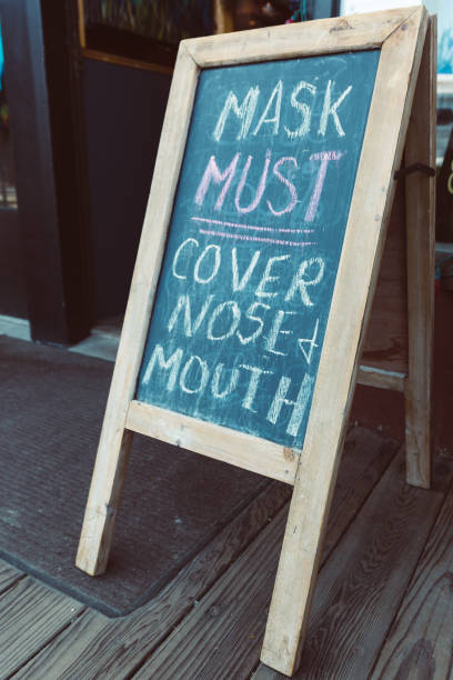 istock Covid Mask Requirements Sign in front of Business 2194706435