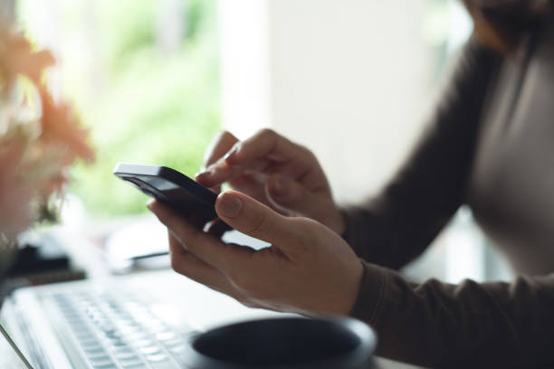 istock Close up, business woman using mobile phone with laptop computer on office table. Woman using smartphone for online shopping and internet banking, social media marketing 2194706591