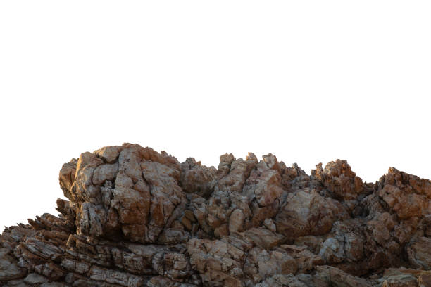 A sunlit rock cliff isolated against a white background. The sun casts warm tones and shadows across the rocky surface, highlighting its layered texture and natural beauty