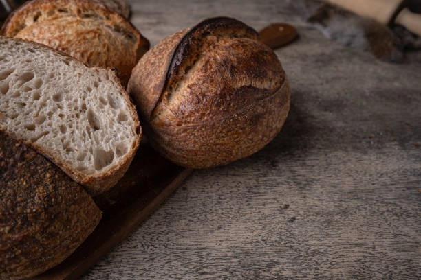 istock Golden-Crusted Artisan Sourdough Bread on a Rustic Wooden Table. 2194707745