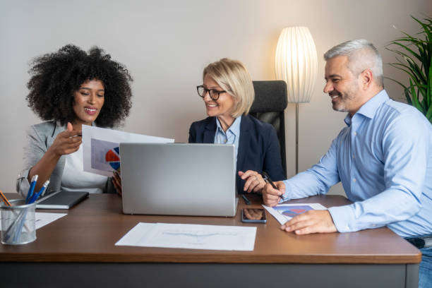 istock Smiling confident businesspeople working together on a laptop in an office 2194708068
