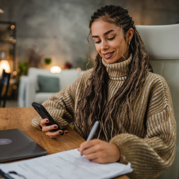 istock young woman work on clipboard and cellphone at home office 2194708970