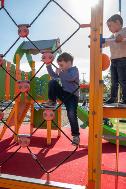 istock Children climbing and playing on playground equipment 2194711767