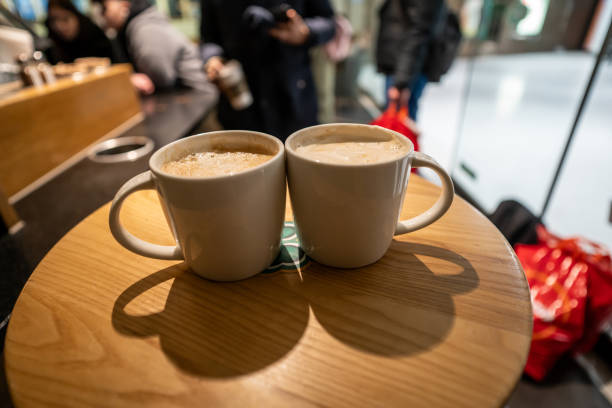 two cup of latte are on table on foreground focus on foreground customers are background horizontal retail still