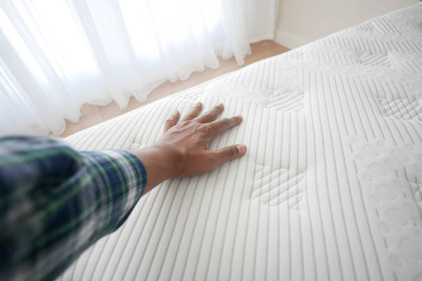 istock Hand touching and pressing orthopedic mattress on bed. 2194713239