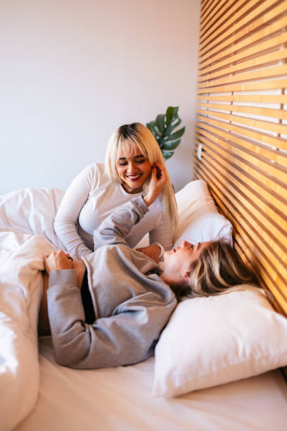 istock Two smiling women lying and playing in bed on valentine's day 2194716541