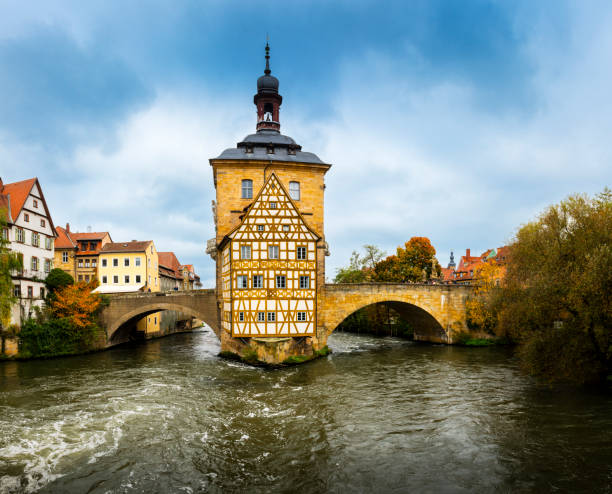 Bamberg, Germany - October 31, 2024: some tourists are on the bridge to the famous old cityhall over Regnitz River in Bamberg in bavaria in Germany