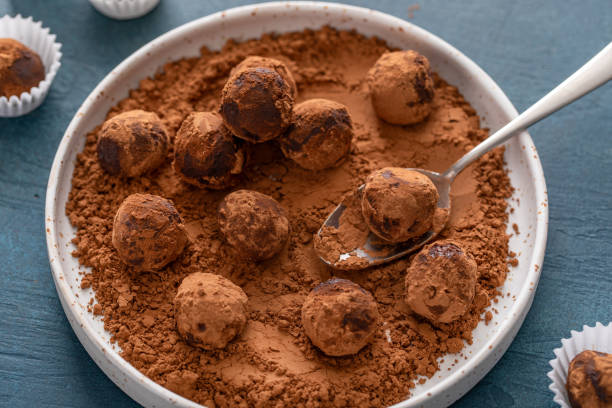 istock Artisanal chocolate truffles dusted with cocoa powder on a plate with a spoon 2194717704
