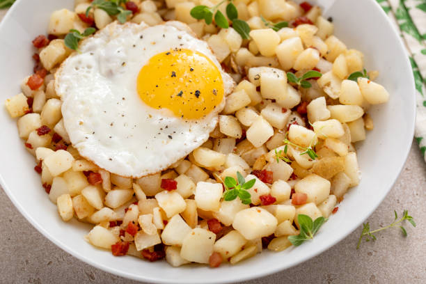 Classic breakfast potato hash with fried egg and ham or bacon
