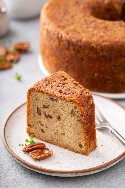 Pecan caramel pound cake baked in a bundt pan slice on a plate Pecan caramel pound cake baked in a bundt pan, homemade and slice served on a plate walnut cookies stock pictures, royalty-free photos & images