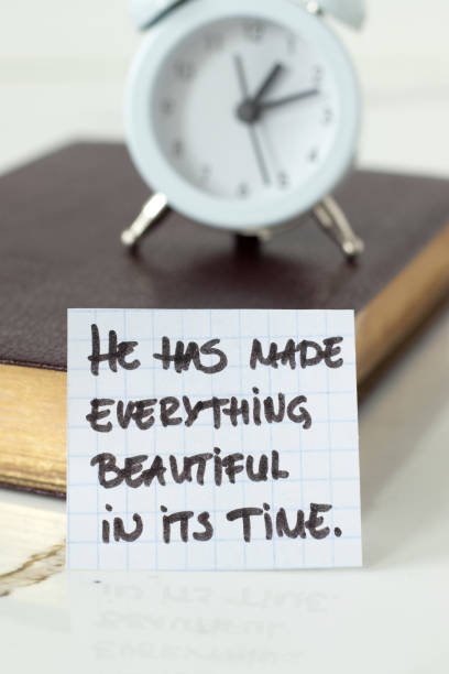 istock He has made everything beautiful in its time, handwritten Christian text with alarm clock and holy bible book 2194722910